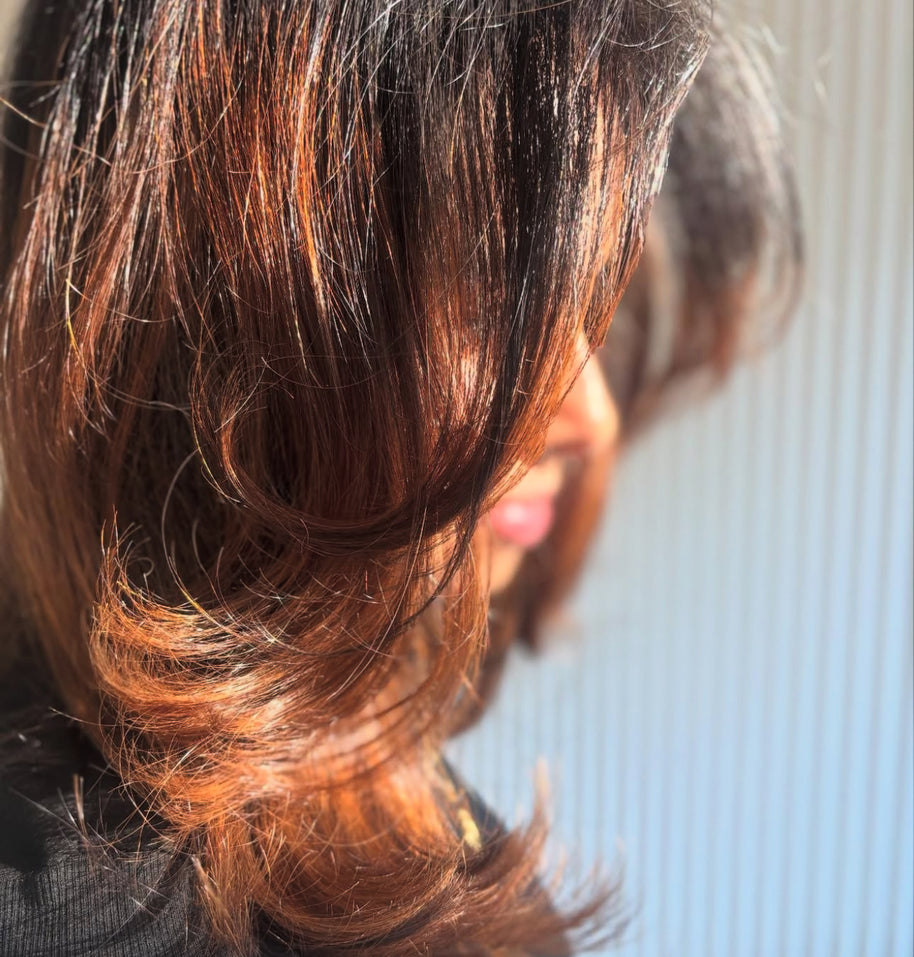 Close-up of a person with styled hair against a neutral background