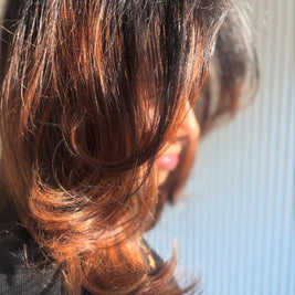Close-up of a person with styled hair against a neutral background