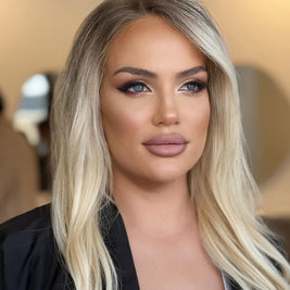 Woman with blonde hair and makeup against a blurred background